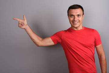 Man wearing red shirt against gray background