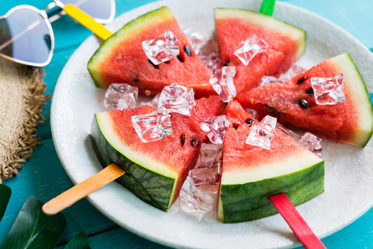 Watermelon slice popsicles with colorful stick on wooden background, Summer fruits