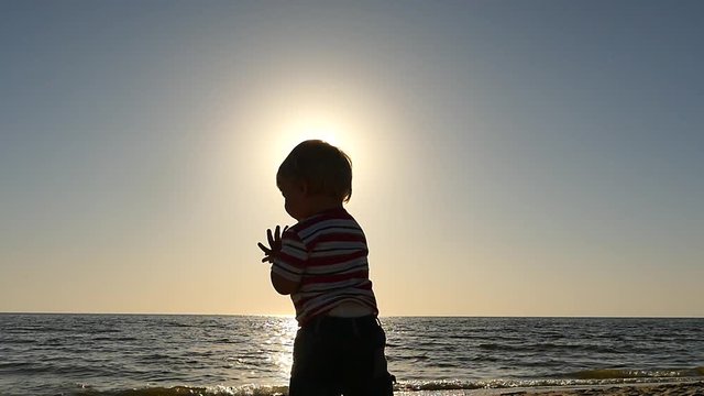 cute 1 + old baby applauds at seascape slow motion silhouette panoramic shot