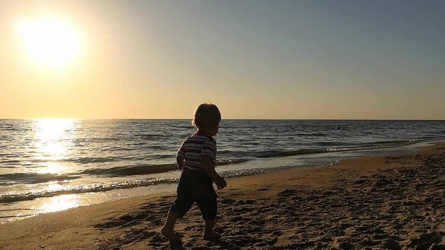 surprised 1+ years boy runs and stops near sea shore silhouette slow motion