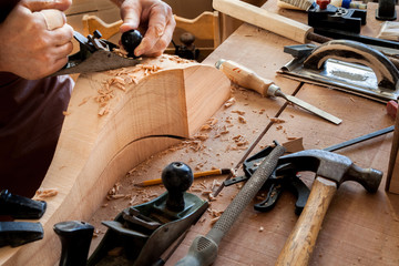 Joiner Makes Cabriole Leg for Vintage Table. Carpenter works with a planer in a workshop 