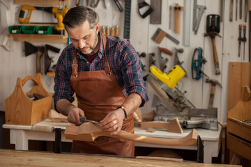 Joiner Makes Cabriole Leg for Vintage Table. Carpenter works with a planer in a workshop 