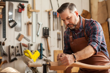 Joiner Makes Cabriole Leg for Vintage Table. Carpenter works with a planer in a workshop 
