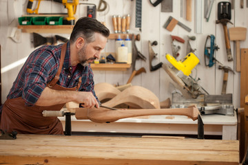 Joiner Makes Cabriole Leg for Vintage Table. Carpenter works with a planer in a workshop 