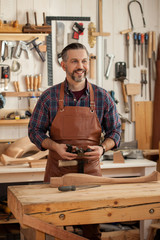 Joiner Makes Cabriole Leg for Vintage Table. Carpenter works with a planer in a workshop