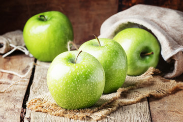 Green apples on vintage wooden background, selective focus