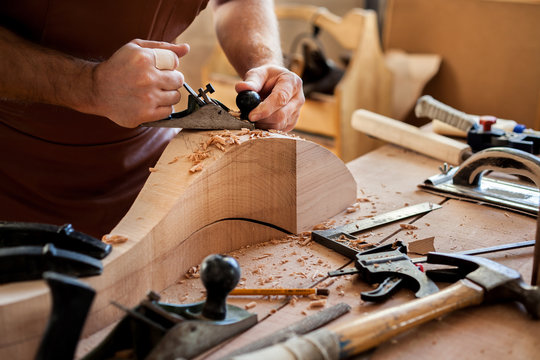 Joiner Makes Cabriole Leg for Vintage Table. Carpenter works with a planer in a workshop 