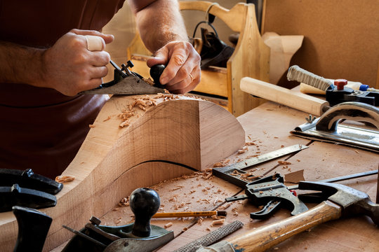 Joiner Makes Cabriole Leg for Vintage Table. Carpenter works with a planer in a workshop 