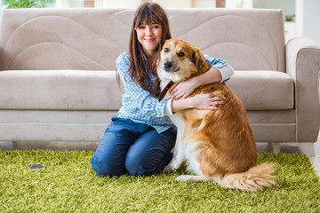 Happy woman dog owner at home with golden retriever