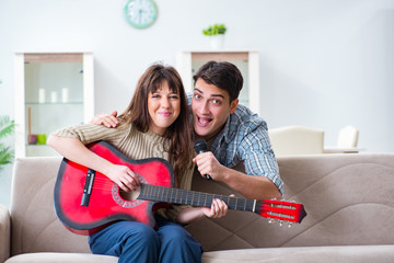 Young family singing and playing music at home