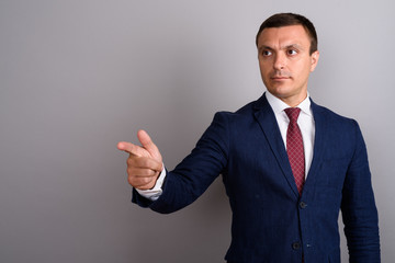 Businessman wearing suit against gray background