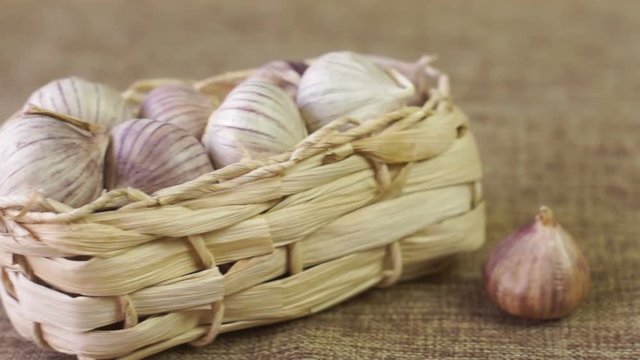 Basket with garlic lies on linen cloth, pan