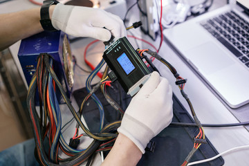 Work with a the computer's power supply. Microelectronics device. Close-up hands of a service...