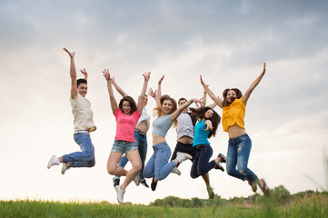 Young people jumping against the sunset sky