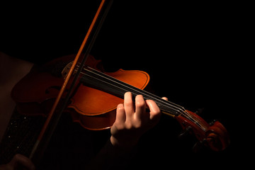 Violin and bow in the hands of musician isolated on black