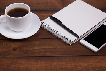coffee cup,notepad ,pen , cell phone wooden background