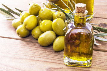 olives and bottle of extra virgin olive oil on wood