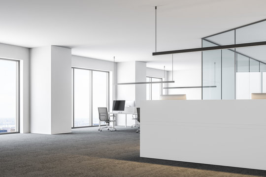 Open space office with a white reception desk side