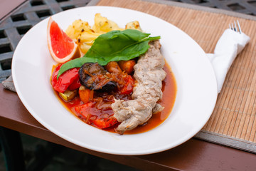 roasted meat with grilled vegetables and juicy sauce on the table