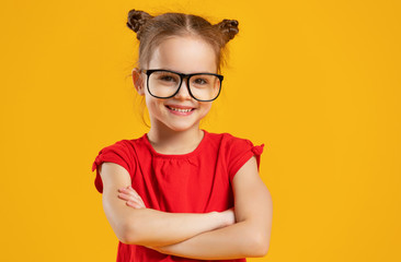 funny child girl in glasses on colored background