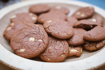 brown chocolate cocoa biscuits with white chocolate on a wooden plate