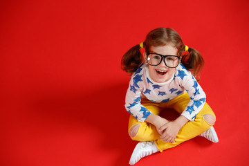 funny child girl in glasses on colored background