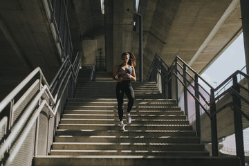 Young woman running alone down stairs