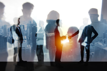 Handshaking business person in office. concept of teamwork and partnership. double exposure