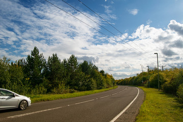 Fototapeta premium Curved road with a car. Sunny summer day