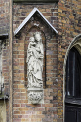 Obraz premium Detail of a brick cathedral in the Gothic style. Carved figure of the Virgin Mary on the side facade. St.Mary Magdalene Church.Wroclaw,Poland.