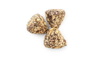 Three chocolate candies covered by flakes on white background. Top view.