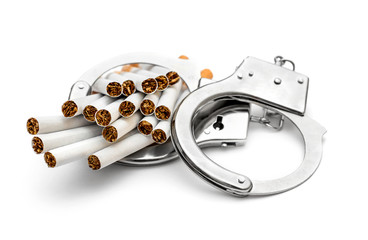 Handcuffs with cigarettes on white.