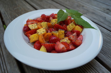  fruit salad in a plate of mango, physalis, strawberry and chia seeds