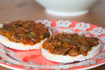 Stuffed mixed vegetables with tomato sauce on gluten free toast served in orange dish