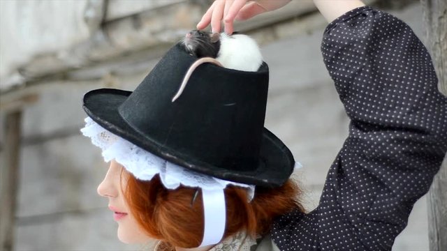 Beautiful red-haired girl posing with hand-made rat. close-up
