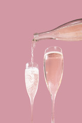 Valdobbiadene Prosecco flutes and a bottle, pink background, in pop contemporary style