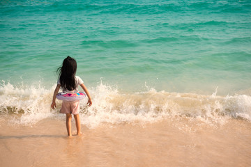 baby  kid girl alone is stand beside strong wave on the beach. Dangerous hazardous Concept.