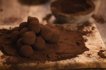 craft chocolate truffles on wooden board with cocoa powder
