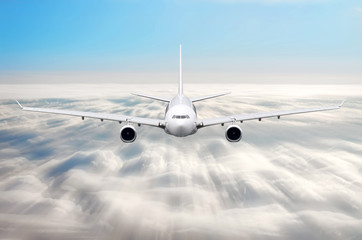 Fototapeta na wymiar Airplane in the sky above the clouds flight journey sun height speed motion blur.
