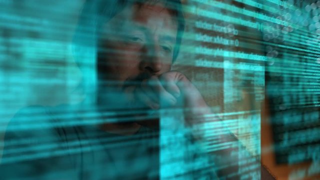 Freelance web designer and site developer is drinking coffee and analyzing script code in dark home office, low key footage