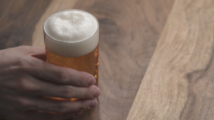 man hand take ginger beer in a glass on wood table