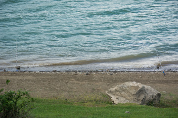 two spinning, fishing on the small lake in the city