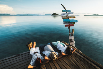 Relaxed outdoor portrait of happy young asian family resting on deck near the sea, Koh Mak Thailand
