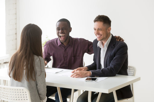 Multiracial hr managers laughing at funny humor joke during job interview talking to woman applicant, candidate makes good first impression at excited african and caucasian recruiters, hiring concept