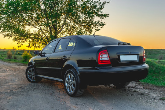 Black Car On The Road At Sunset