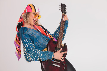 woman with colored clothes performing a rock concert on guitar