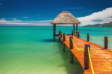 Red wooden jetty extending to tropical ocean in Fiji