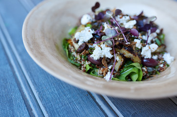 Healthy mixed vegetable salad sitting on a rustic blue table
