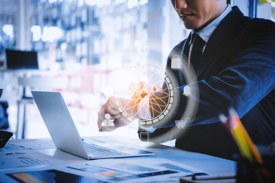 Business man setting smart watch digital with application icons for shipping , working ,mail at the desk in office. business technology and innovations concept.