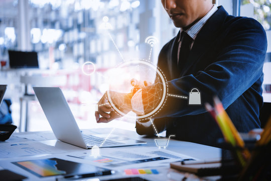Business man setting smart watch digital with application icons for shipping , working ,mail at the desk in office. business technology and innovations concept.